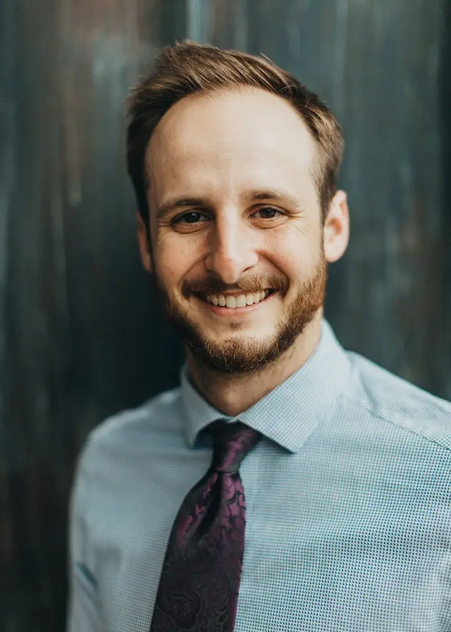 Nathan Brown, DPT, OCS, against a dark teal wall